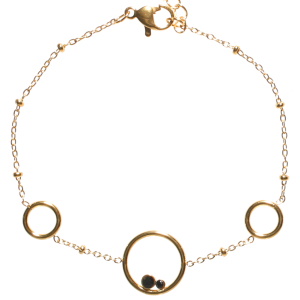Bracelet composé d'une chaîne avec trois cercles en acier doré et de deux cristaux de couleur noir sertis clos. Fermoir mousqueton avec 3 cm de rallonge.