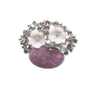 Broche en métal argenté composée de strass, de deux fleurs en matière synthétique et d'une pierre ovale de couleur violette.