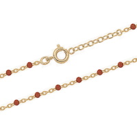 Bracelet composé d'une chaîne en plaqué or jaune 18 carats et de perles en résine de couleur rouge. Fermoir anneau ressort avec 3 cm de rallonge.