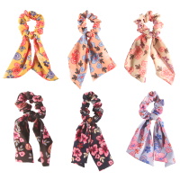Chouchou élastique pour cheveux en forme de foulard noué en textile de couleur avec motifs de fleurs. 6 coloris différents. Vendu à l'unité.