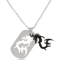 Collier composé d'une chaîne en acier argenté et d'un pendentif plaque rectangulaire aux coins arrondis avec motif ajouré d'un dragon en acier argenté 316L et d'un pendentif dragon en acier de couleur noire.