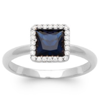 Bague en argent 925/000 rhodié surmontée d'une pierre de couleur bleue sertie clos de forme carré entourée d'un pavage d'oxydes de zirconium blancs.