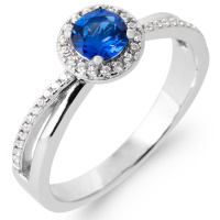 Bague en argent 925/000 rhodié pavée en partie d'oxydes de zirconium blancs et surmontée d'une pierre de couleur bleue sertie 4 griffes de forme ronde.