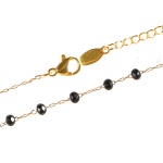 Bracelet en acier doré composé de perles de couleur noire.