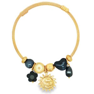 Apportez une touche de mystère et d'élégance céleste à votre poignet avec ce magnifique bracelet jonc pour femme. Alliant la robustesse de l'acier et le raffinement de finitions dorées éclatantes, ce bijou se distingue par son design texturé et ses charms soigneusement sélectionnés. Un jonc rigide en acier doré au fini torsadé (effet câble), offrant à la fois de superbes reflets de lumière et une excellente résistance au quotidien. Une magnifique médaille représentant un soleil souriant aux rayons flamboyants, symbole de vitalité et de clarté. Des perles en acier doré lisse et ciselé pour le contraste. Des éléments noirs profonds contrastants, incluant un charm en forme de fleur noire mat, une perle texturée en forme de cœur, et une délicate goutte noire suspendue.