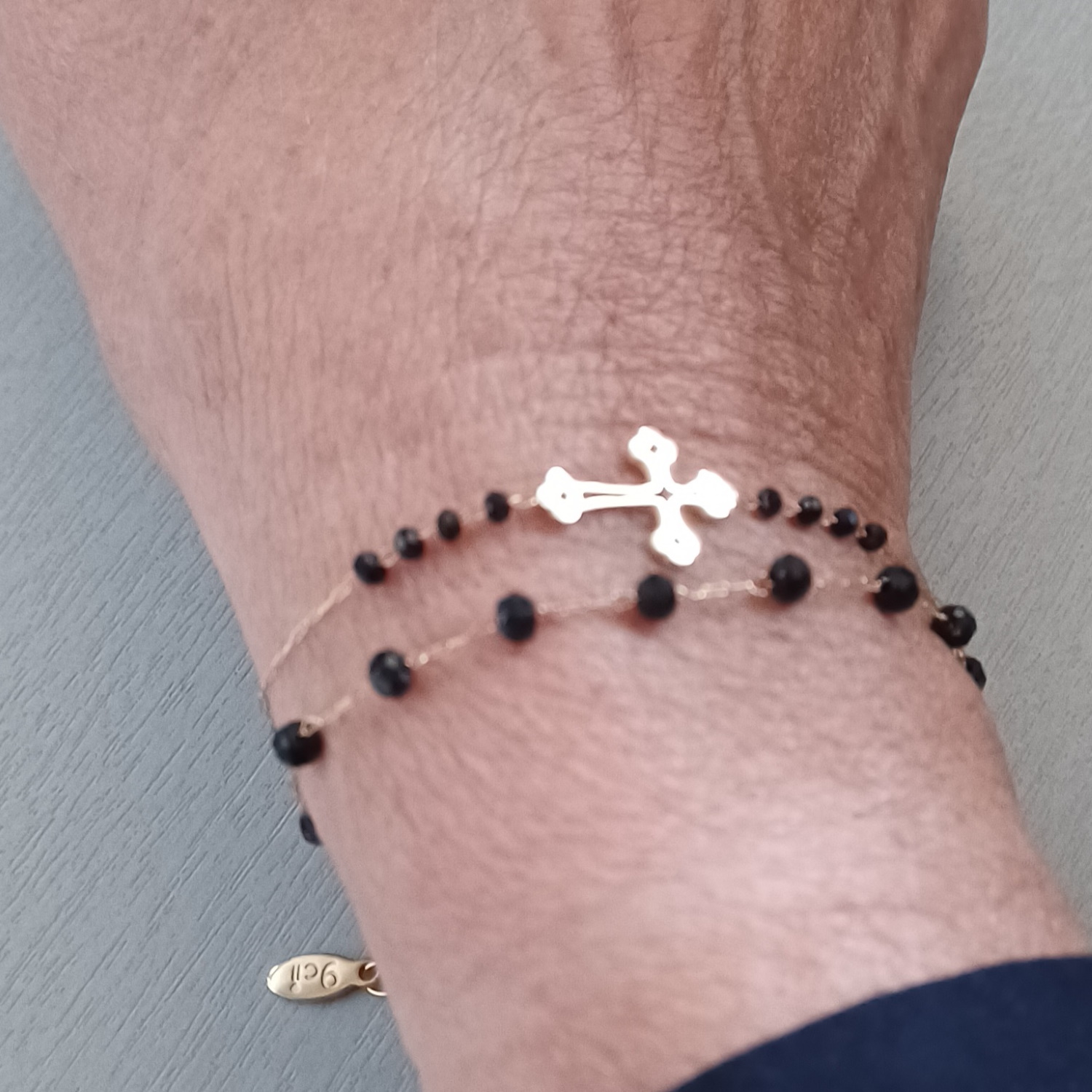 Bracelet composé d'une chaîne et d'une croix en acier doré et de perles de couleur noire.<br/>Fermoir mousqueton avec 2.5 cm de rallonge. Croix Perle  Adolescent Adulte Femme Fille Indémodable Religion Symboles 