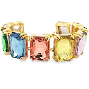 Le bracelet se distingue par son style art déco moderne, composé d'une succession de cristaux de grande taille aux couleurs vives. Chaque pierre est taillée en octogone (taille émeraude), offrant une profondeur et une brillance maximales grâce à ses multiples facettes. La palette chromatique est riche et variée, incluant des teintes de bleu saphir profond, rose morganite délicat, jaune citrine lumineux, vert émeraude vibrant et lilas doux Équipé d'une chaînette d'extension permettant d'adapter parfaitement la taille à toutes les morphologies de poignet.