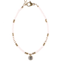 Bracelet composé de perles cylindriques en acier doré, de perles cylindriques en caoutchouc de couleur blanc et d'un pendant rond serti d'un cristal. Fermoir mousqueton avec 3 cm de rallonge.