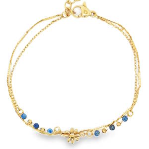 Sublime bracelet double rangs chaîne en acier doré, rehaussé de délicates perles bleues et d'un motif floral ajouré. Ce bijou raffiné, ajustable grâce à sa chaînette, apportera une touche d'éclat discret à votre poignet. Un accessoire précieux pour sublimer votre style. Fermoir mousqueton avec 3 cm de rallonge.