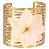 Bracelet manchette ouvert en acier doré surmonté d'une fleur de couleur blanche.