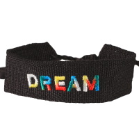 Bracelet fantaisie avec le mot Dream en textile de couleur noir. Fermoir cordon nœud coulissant avec pompons.