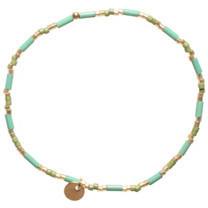 Bracelet élastique composé de perles cylindriques en acier doré et perles cylindriques de couleur verte.