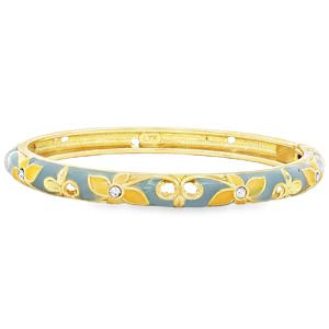 Succombez au charme poétique de ce bracelet jonc pour femme, une pièce délicate qui mêle habilement l'éclat du métal doré à la douceur de l'émail coloré. Conçu avec un grand sens du détail, ce bijou apporte une touche de fraîcheur et de sophistication à votre poignet. Le bracelet est orné d'un délicat motif de fleurs à quatre pétales et de volutes végétales en relief doré, s'inspirant d'un style printanier et romantique. Le fond du jonc arbore un fini lisse couleur gris bleuté, contrasté par le jaune doux et lumineux qui habille les pétales des fleurs. Le cœur de chaque fleur est incrusté d'un petit cristal scintillant, captant magnifiquement la lumière à chaque mouvement.