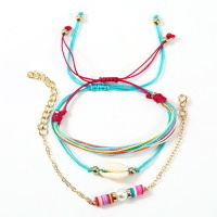 Lot de 3 bracelets fantaisie composé d'un bracelet en cordon de couleur turquoise et d'un coquillage cauri, d'un bracelet de 10 cordons de couleur et d'un bracelet chaîne en métal doré avec perles cylindriques en caoutchouc et une perle d'imitation.