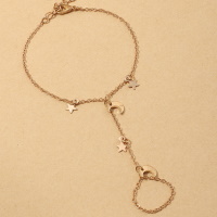 Bracelet bague avec pampilles étoiles et croissants de lune en métal doré. Fermoir mousqueton avec 5 cm de rallonge.