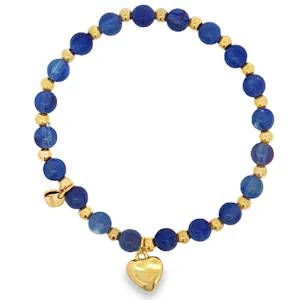 Sublime bracelet élastique de perles en acier doré, agrémenté de sphères bleues profondes taillées en cabochon. Un bijou exquis, symbole d'élégance et de raffinement. Chaque perle est soigneusement sélectionnée pour sa couleur intense et sa qualité exceptionnelle, offrant un contraste saisissant avec l'éclat chaleureux de l'acier doré.