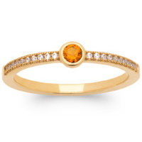 Bague en plaqué or jaune 18 carats pavée d'oxydes de zirconium blancs surmontée d'une pierre synthétique de couleur orange serti clos de forme ronde.