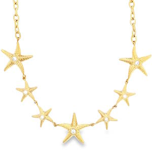 Apportez une touche de poésie marine à votre décolleté avec ce collier raffiné. Conçu en acier inoxydable de haute qualité, ce bijou allie la robustesse du métal à la délicatesse d'un design d'inspiration océanique. Le collier se compose d'une série de sept étoiles de mer finement ciselées, capturant l'essence même des vacances et du bord de mer. Chaque étoile est texturée pour un rendu réaliste et ornée en son centre d'un cristal scintillant, apportant une touche de lumière discrète mais élégante. Sa dorure éclatante offre un rendu solaire qui sublimera particulièrement les peaux halées.