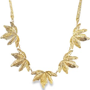 Ce collier en acier doré se distingue par son motif botanique raffiné. Il se compose de cinq feuilles de vigne (ou d'érable) délicatement ciselées, disposées en demi-cercle pour épouser parfaitement la ligne de votre décolleté. Chaque feuille présente des détails de nervures précis, offrant une texture riche et un réalisme saisissant. La monture est suspendue à des cordons en forme de chaîne maillée élégante, apportant une touche moderne et sophistiquée à l'ensemble. Un mousqueton sécurisé accompagné d'une chaînette d'extension, permettant d'ajuster parfaitement la taille à votre morphologie.