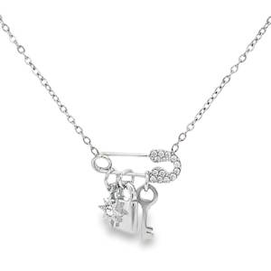 Apportez une note audacieuse et moderne à votre boîte à bijoux avec ce collier en acier inoxydable. Son design original met en scène une épingle à nourrice stylisée, servant de support à trois charms délicats qui dansent au gré de vos mouvements. L'Épingle à Nourrice est l'élément central du bijou, elle est rehaussée de strass étincelants sur sa tête, offrant un contraste parfait entre le style industriel et le luxe. Une étoile polaire sertie d'un cristal central pour la guidance. Un cadenas lisse, symbole de protection ou de jardin secret. Une petite clé, évoquant la liberté ou le mystère.