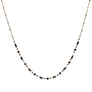 Collier composé d'une chaîne avec perles en acier doré et de perles de couleur noire et grise. Fermoir mousqueton avec 5 cm de rallonge.
