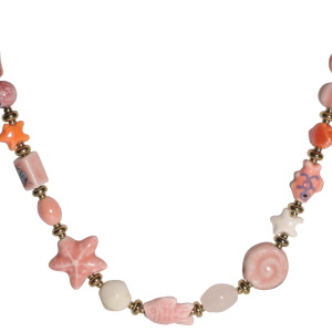 Collier composé d'un cordon rose, de perles en acier doré et de perles en forme de coquillages, de poisson et d'étoiles en céramique. Fermoir mousqueton avec 5 cm de rallonge.