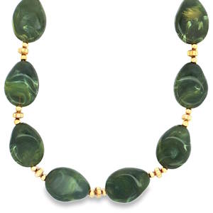 Ce collier orné de perles vertes taillé en cabochon, est une ode à l'élégance naturelle. Les perles d'un vert profond, sont mises en valeur par des accents dorés, créant un contraste chaleureux. Ce bijou unique est idéal pour ajouter une touche de raffinement à votre style. Fermoir mousqueton avec 5 cm de rallonge.