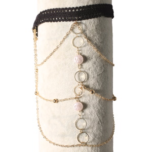 Bracelet de bras composé d'un cordon de couleur noir et de chaîne en métal doré avec deux pastilles rondes de couleur blanche nacrée. Fermoir mousqueton avec 7 cm de rallonge.