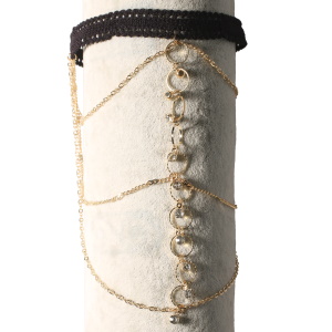 Bracelet de bras composé d'un cordon de couleur noir et de chaînes avec cercles en métal doré et des strass. Fermoir mousqueton avec 7 cm de rallonge.