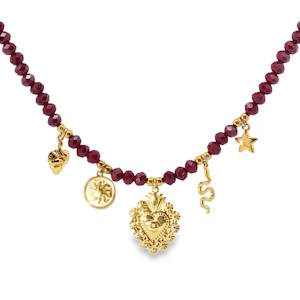 Ce collier en acier doré est orné de perles rouge foncé facettées, créant un contraste captivant. Les breloques dorées, incluant un cœur sacré, une étoile, un serpent et un soleil, ajoutent une touche mystique et symbolique. Idéal pour celles qui cherchent à exprimer leur individualité avec élégance et originalité. Fermoir mousqueton avec 5 cm de rallonge.