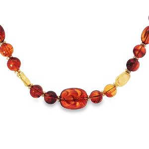 Ce collier de perles couleur ambre, rayonnant d'une teinte rouge orangé chaleureuse, présente des perles rondes taillées en cabochon. Chaque perle révèle une clarté VS, promettant un éclat sans imperfections majeures. La symétrie et le poli sont impeccables, témoignant d'un savoir faire de qualité. Ce bijou dégage une élégance intemporelle. Mousqueton avec 4 cm de rallonge.