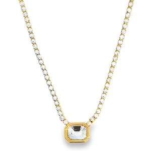 Ce collier pendentif exquis en acier doré est orné d'un cristal de taille émeraude à degrés. Sa clarté impeccable et sa symétrie confèrent un éclat exceptionnel. Un design délicat qui offre une composition charmante, idéale pour ajouter une touche d'élégance discrète à votre collection de bijoux.