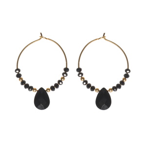 Boucles d'oreilles créoles en acier doré surmontées de perles de couleur noire avec une pierre en forme de goutte de couleur noire.