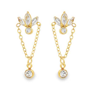 Apportez une touche de sophistication et de modernité à votre allure avec ces magnifiques boucles d'oreilles pendantes. Le sommet de la boucle est orné d'un motif en forme de fleur de lotus ou de lys, composé de trois cristaux étincelants taillés en marquise. Ces pétales de lumière encadrent un petit solitaire rond serti clos, créant un point focal brillant au creux de l'oreille. Deux fines chaînes en maille forçat partent des extrémités latérales de la fleur pour se rejoindre en un point bas. Ce mouvement fluide accompagne délicatement les gestes de celle qui les porte. À la pointe de cette suspension, un cristal rond plus généreux, également serti clos dans une monture dorée, vient parfaire l'équilibre visuel de la boucle. Ce dernier élément apporte une note de mouvement et un éclat supplémentaire qui capte la lumière sous tous les angles.