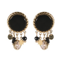 Boucles d'oreilles pendantes composées d'une pastille ronde en acier doré pavée d'une pierre de couleur noire et de pendants étoile et pastille ronde en acier doré, perles de couleur noire et d'un cristal serti clos en forme de goutte.