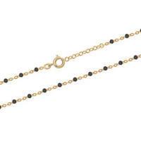 Bracelet chaîne cheville composé d'une chaîne en plaqué or jaune 18 carats et de perles en résine de couleur noire. Fermoir anneau ressort avec 2 cm de rallonge.