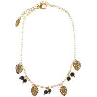 Bracelet chaîne de cheville composé d'une chaîne et de pampilles feuilles philodendron en acier doré et de pampilles perles de couleur noire. Fermoir mousqueton avec 3 cm de rallonge.