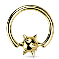 Piercing anneau avec une balle surmontée de piques en acier doré.