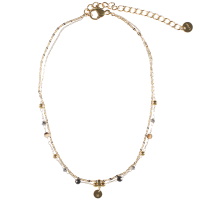 Bracelet chaîne de cheville double rangs composé d'une chaîne en acier doré et d'une chaîne avec perles en acier doré et de perles de couleur noire. Les deux chaînes sont attachées avec une pampille ronde représentant une étoile. Fermoir mousqueton avec 5 cm de rallonge.
