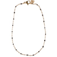 Bracelet chaîne de cheville composé d'une chaîne en acier doré et de perles en émail de couleur noir. Fermoir mousqueton avec 7 cm de rallonge.