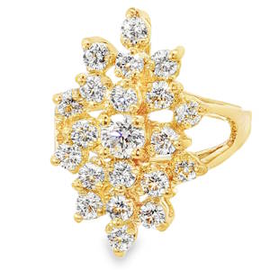 Laissez-vous séduire par cette bague spectaculaire qui allie l’élégance intemporelle du doré à la brillance intense des pierres. Conçue comme une véritable pièce de joaillerie, elle sublime la main d'un éclat incomparable. Le plateau de la bague présente une structure complexe et aérienne évoquant un bouquet de fleurs étincelant. Une multitude de cristaux de différentes tailles sont minutieusement sertis pour capturer la lumière sous tous les angles. Le centre est dominé par une pierre plus imposante, accentuant l'effet de profondeur. La structure est réalisée en plaqué or 18 carats, offrant une finition chaleureuse et une brillance durable qui met parfaitement en valeur la pureté des pierres blanches.