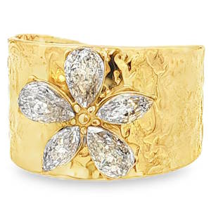 L'éclat somptueux d'un anneau cocktail en acier doré. Une composition florale éblouissante orne ce bijou exceptionnel, sertie de strass en forme de poire taille brillant, chacun captant la lumière avec une clarté et une symétrie remarquables. Un chef-d'œuvre de joaillerie pour une élégance affirmée. Taille ajustable.