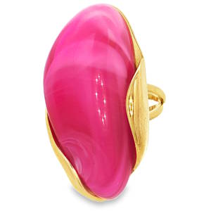 Cette bague est une véritable pièce d'affirmation, alliant un design organique audacieux à une couleur vibrante. Cette bague se distingue par son style moderne et sculptural. Elle arbore un imposant cabochon en résine d'un rose magenta intense, dont les nuances marbrées apportent de la profondeur et un aspect vitré captivant. La monture en acier inoxydable finition dorée épouse délicatement les courbes de la pierre. Sa structure ouverte à l'arrière permet de l'ajuster facilement à la taille de votre doigt, garantissant un confort optimal tout au long de la journée.