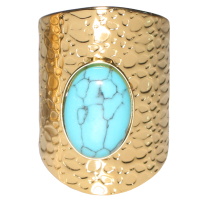 Bague ovale avec motifs en acier doré surmonté d'une véritable pierre de turquoise. Taille ajustable.