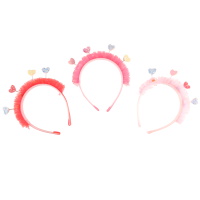 Serre-tête pour cheveux pour enfant recouvert de textile de couleur surmonté de dentelle et de cœurs en suédine pailletés. 3 coloris différents. Vendu à l'unité.