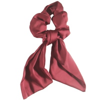 Chouchou élastique pour cheveux en forme de foulard noué en textile satiné de couleur.