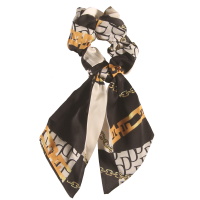 Chouchou élastique pour cheveux en forme de foulard noué en textile de couleur avec motifs.