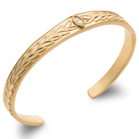 Bracelet jonc rigide ouvert avec motifs en relief de branche de laurier en plaqué or jaune 18 carats surmonté d'un oxyde de zirconium blanc serti clos de forme ovale.