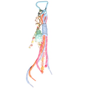 Porte-clés fantaisie composé d'un mousqueton en forme de cœur, de plusieurs cordons noués avec des cœurs, d'un cordon en tissu avec motifs et d'une chaîne avec une tortue verte.