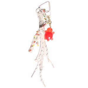 Porte-clés fantaisie composé d'un mousqueton en forme de cœur, de plusieurs cordons noués avec des cœurs, d'un cordon en tissu avec motifs et d'une chaîne avec une tortue rouge.
